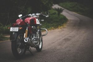Rød motorsykkel på grusvei