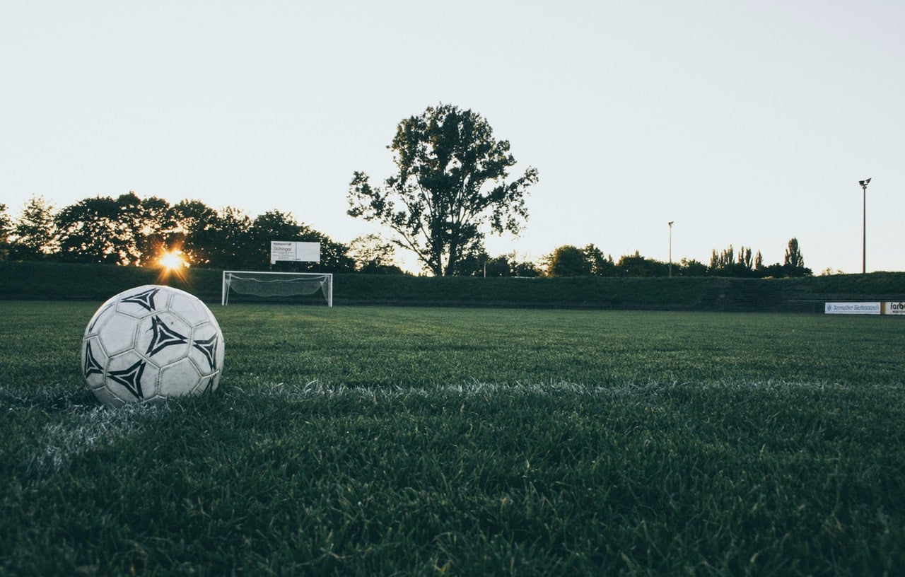 Svart og hvit fotball på fotballbane av gress